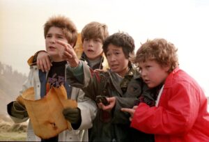 The Goonies cast looking at a treasure map.