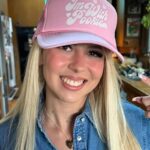 Haliey Welch smiles while wearing a baseball cap.