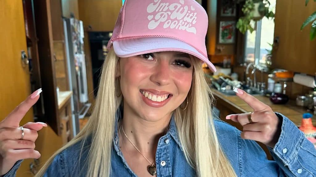 Haliey Welch smiles while wearing a baseball cap.