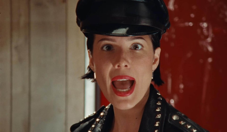 Halsey in a music video, wearing a leather cap and jacket.