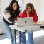 Two women looking at a laptop together.