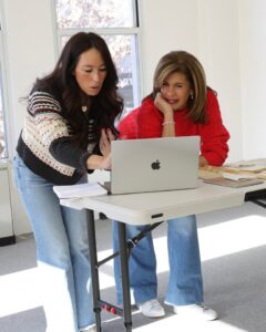 Two women looking at a laptop together.