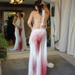 Woman in a white and pink ombre gown in a dressing room.