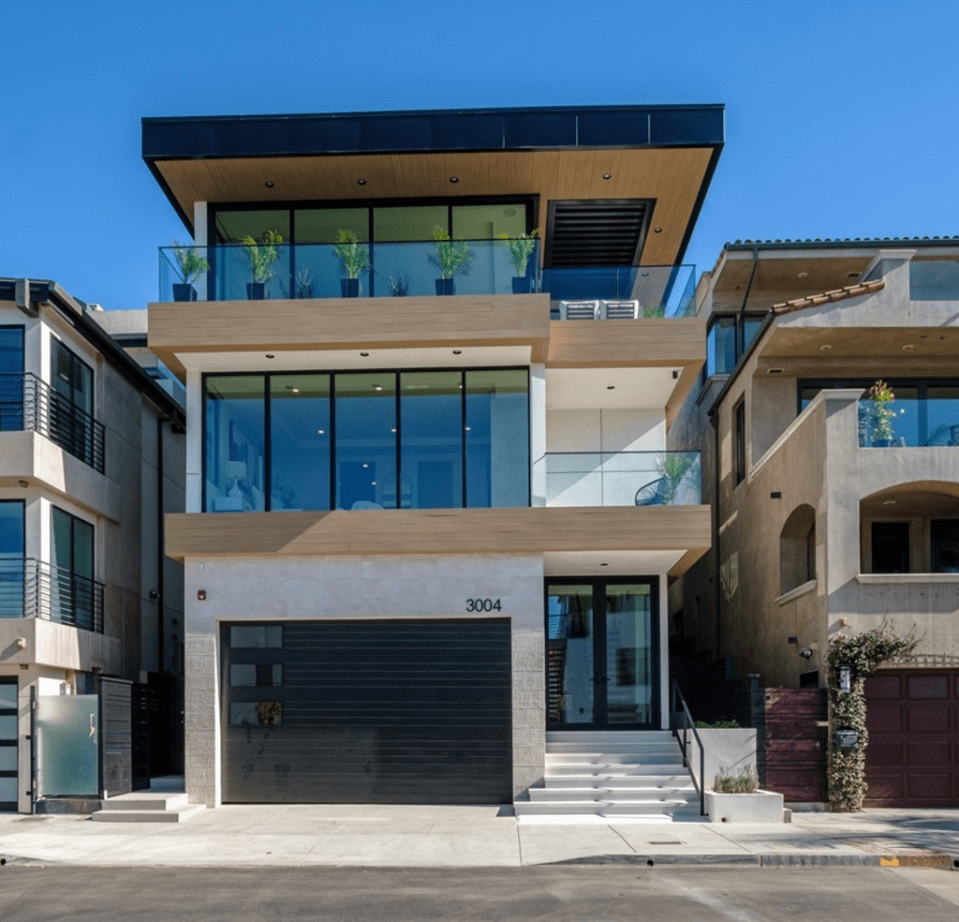 Modern three-story house with a dark garage door.