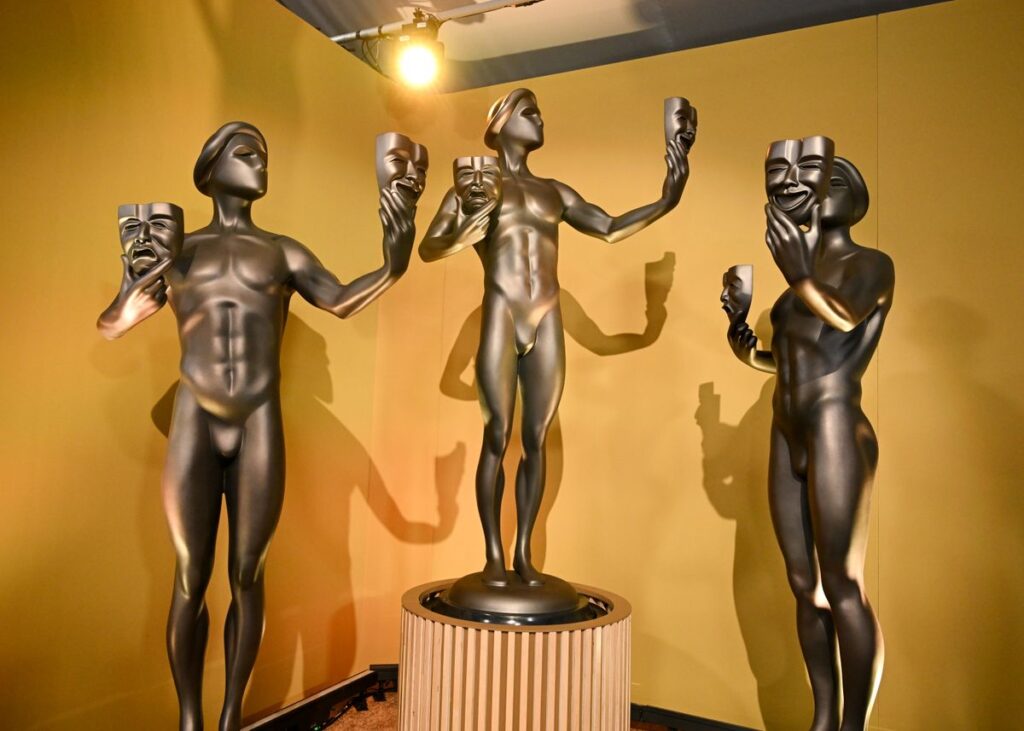 SAG Awards statuettes displayed on a pedestal, featuring the classic actor holding comedy and tragedy masks.