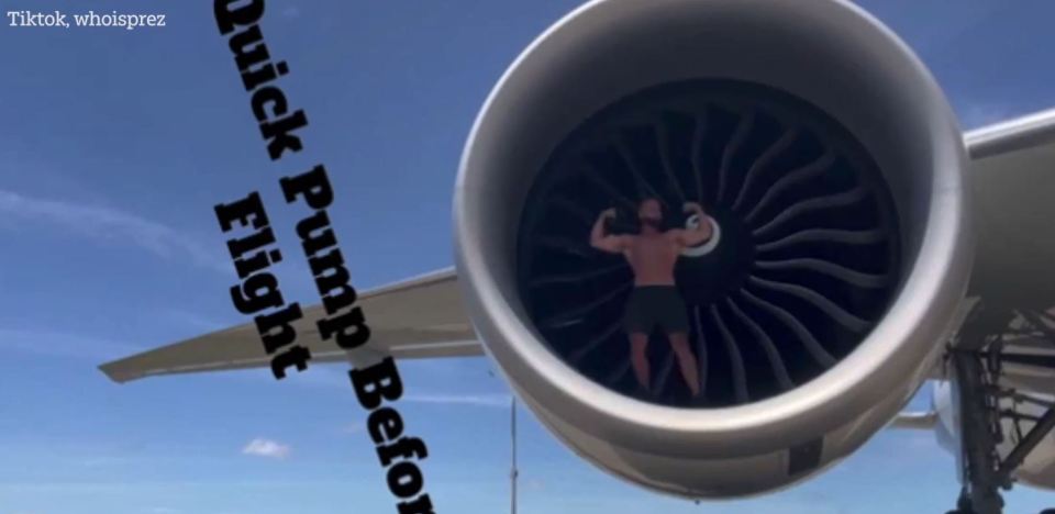 Bodybuilder flexing inside an airplane engine.