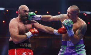 Oleksandr Usyk punches Tyson Fury during a boxing match.