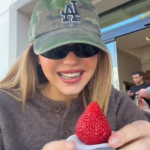 Woman holding a strawberry dessert.