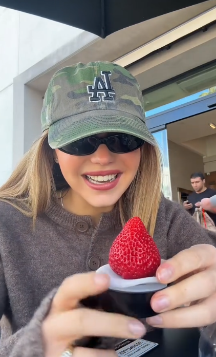 Woman holding a strawberry dessert.