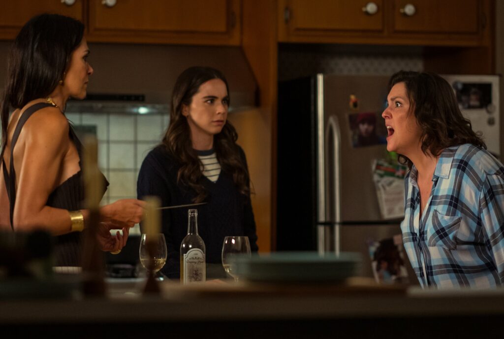 Shauna screaming at Lottie in her kitchen with Callie in the background in a still from Yellowjackets season 3