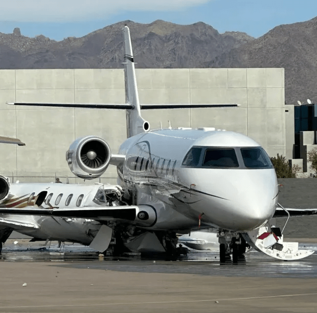 Damaged private jets on tarmac.