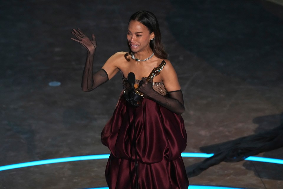 Zoe Saldana accepts an award, crying.