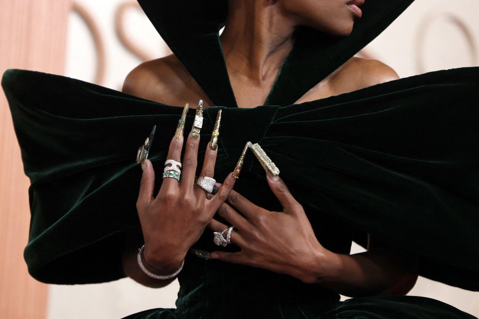 Close-up of Cynthia Erivo's hands adorned with elaborate nail art and jewelry at the Oscars.