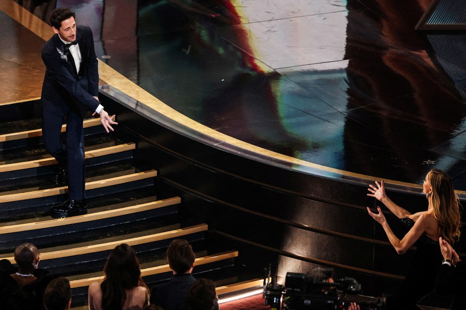 Adrien Brody throws chewing gum to Georgina Chapman at the Oscars.