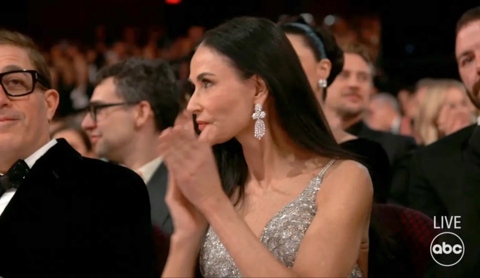 Demi Moore clapping at an awards ceremony.