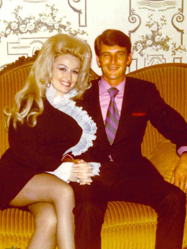 Dolly Parton and Carl Dean sitting on a couch.