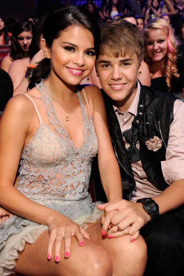 Selena Gomez and Justin Bieber holding hands at an awards show.