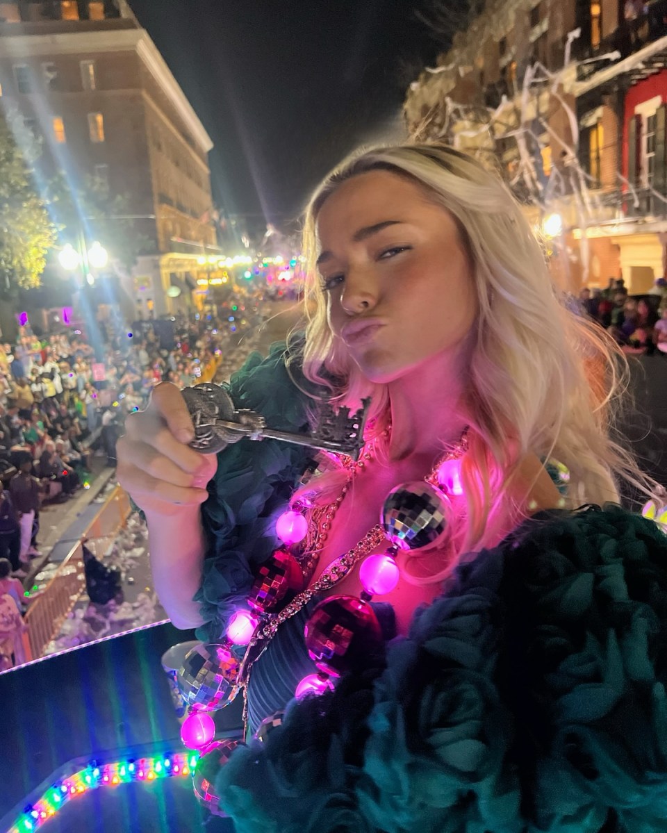 Woman in Mardi Gras parade throws beads.