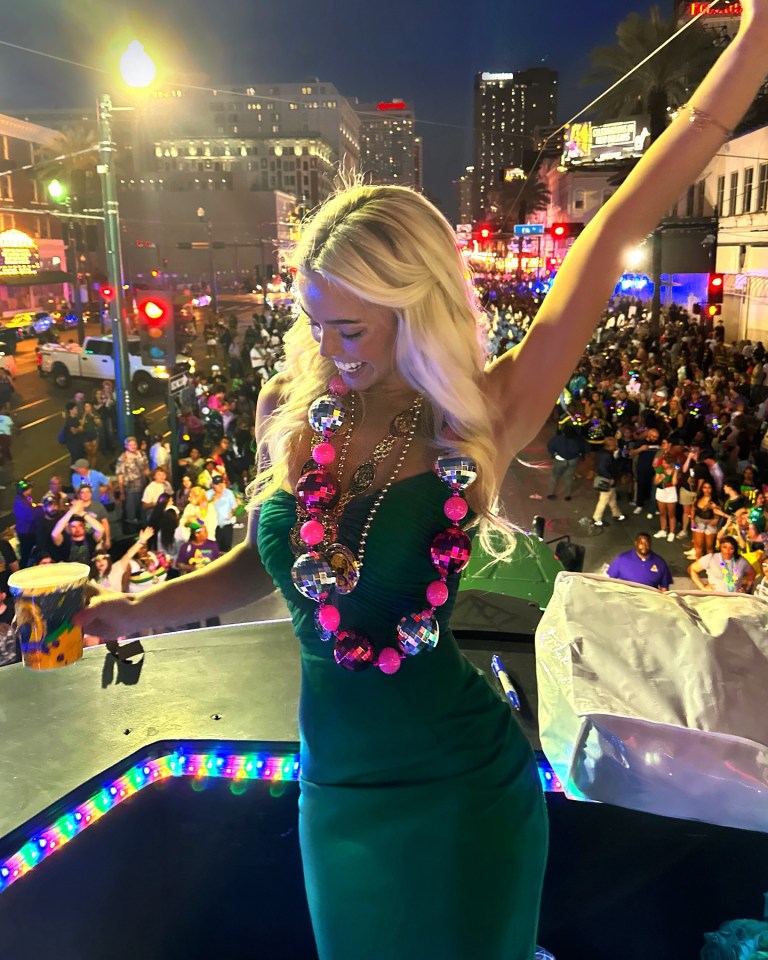 Woman in green dress at Mardi Gras parade.