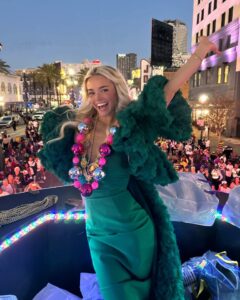 Woman in green dress and beaded necklace on a Mardi Gras float.