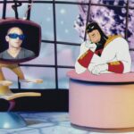 Michael Stipe speaks out of a cartoon TV monitor to Space Ghost, who is seated at a desk like a late-night host