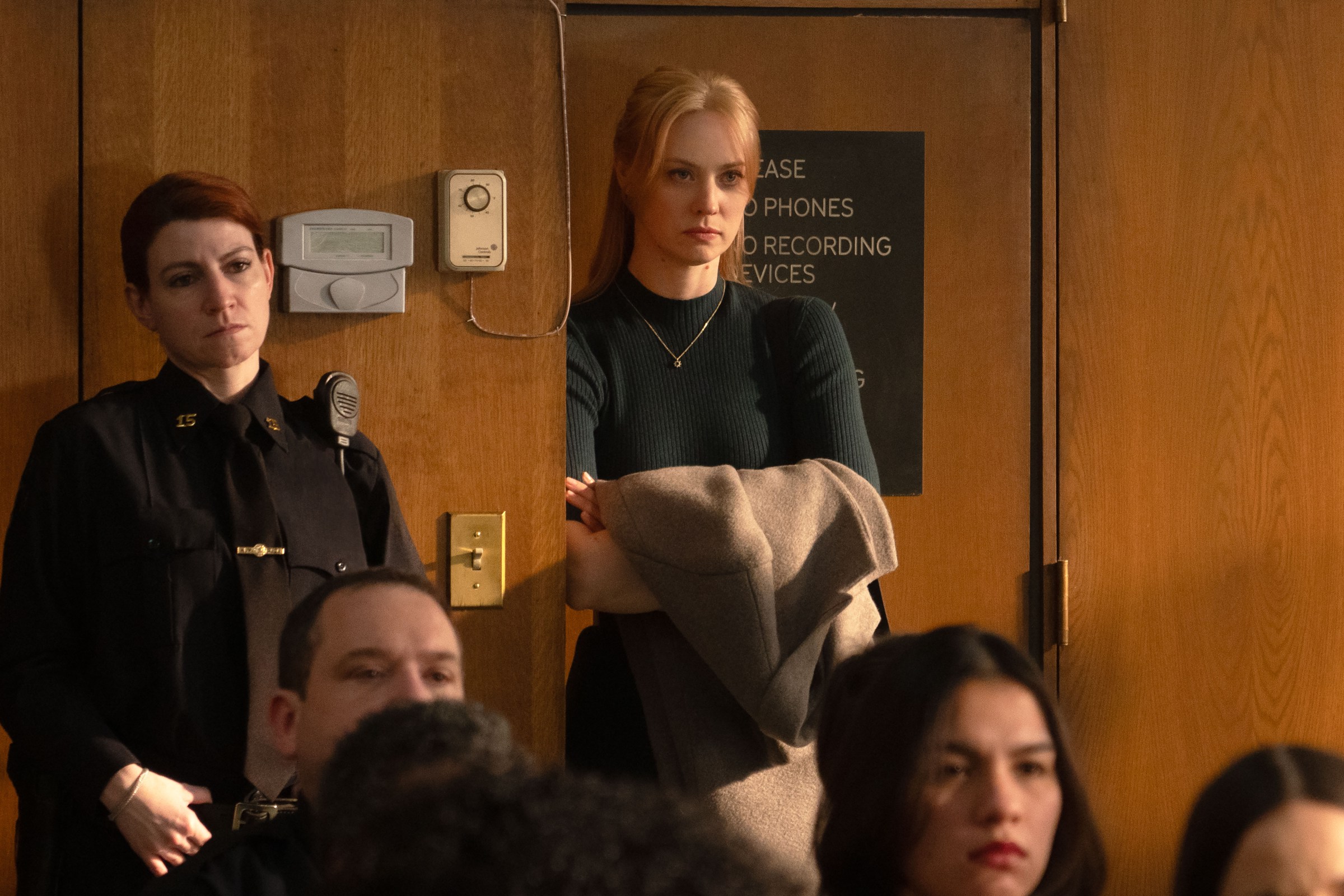 Karen Page (Deborah Ann Woll) stands in the back of a courtroom looking angry in Daredevil: Born Again.