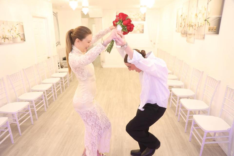 Two people playfully tossing a bouquet of red roses.