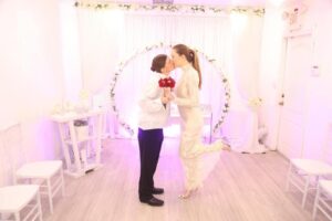 Two women kissing at their wedding ceremony.