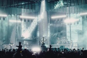 A band performing on a stage surrounded by lights.