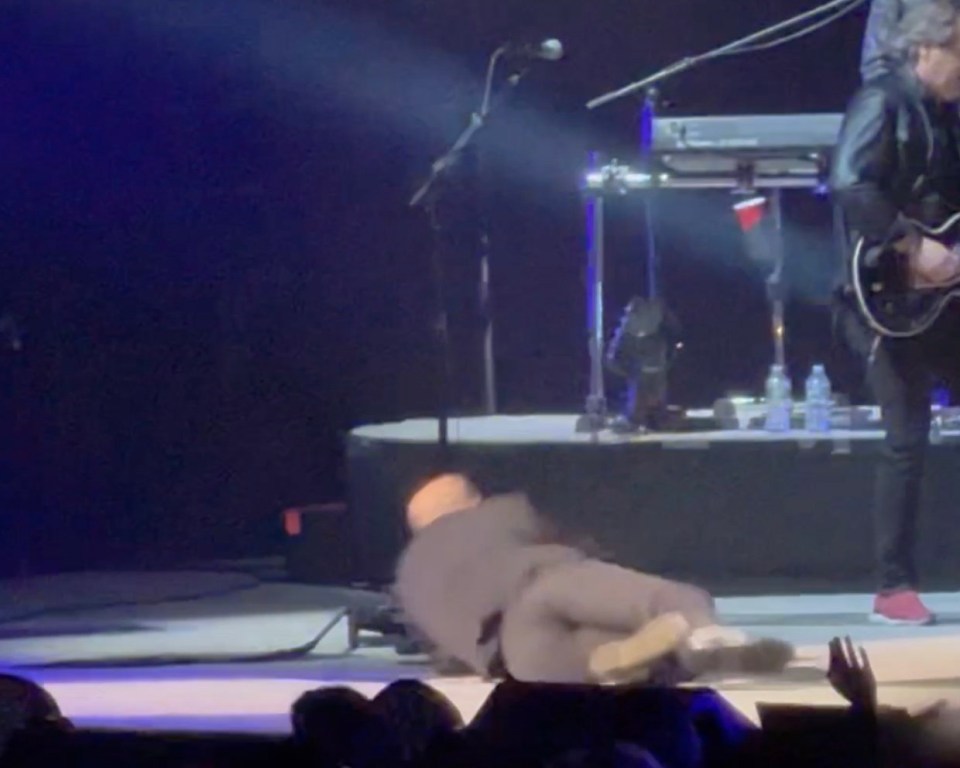 Billy Joel falling on stage during a performance.