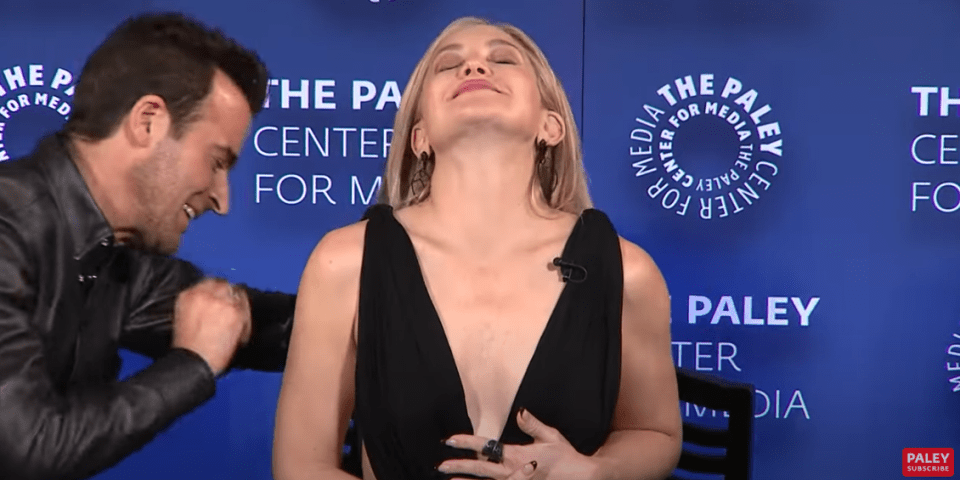 Kate Hudson having a wardrobe malfunction, helped by a man.