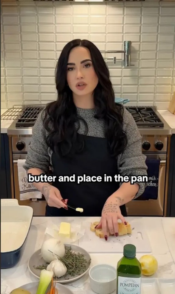 Demi Lovato adding butter to bread in a cooking video.