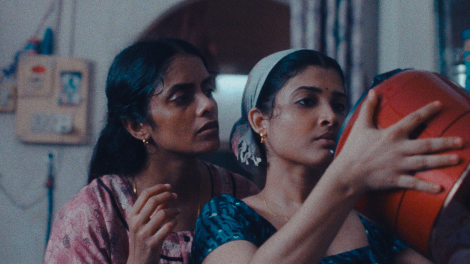 Two women staring at a red rice cooker in All We Imagine As Light.