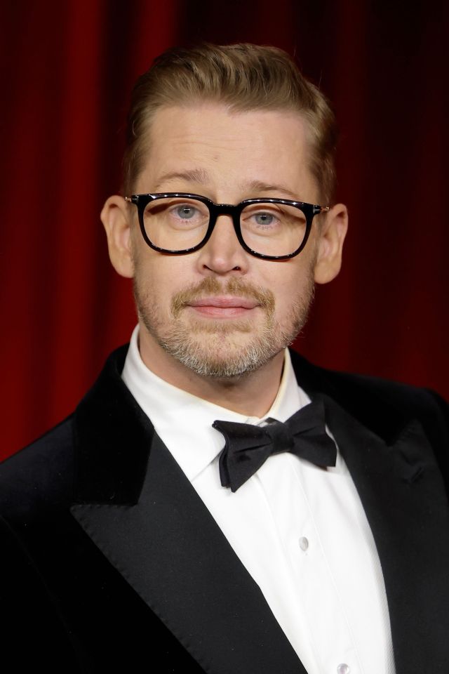 Macaulay Culkin in a tuxedo and glasses.