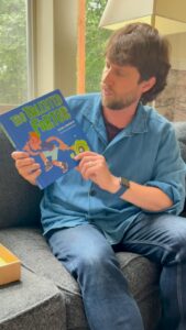 Man reading "The Talented Farter" children's book.