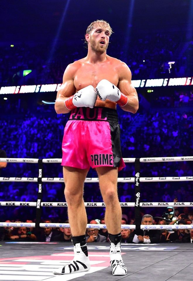 Logan Paul in boxing ring, wearing pink shorts.