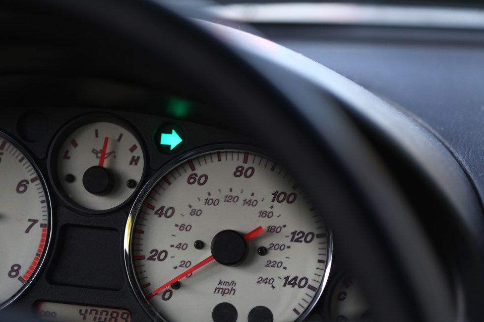 Car dashboard with speedometer and indicator lights.