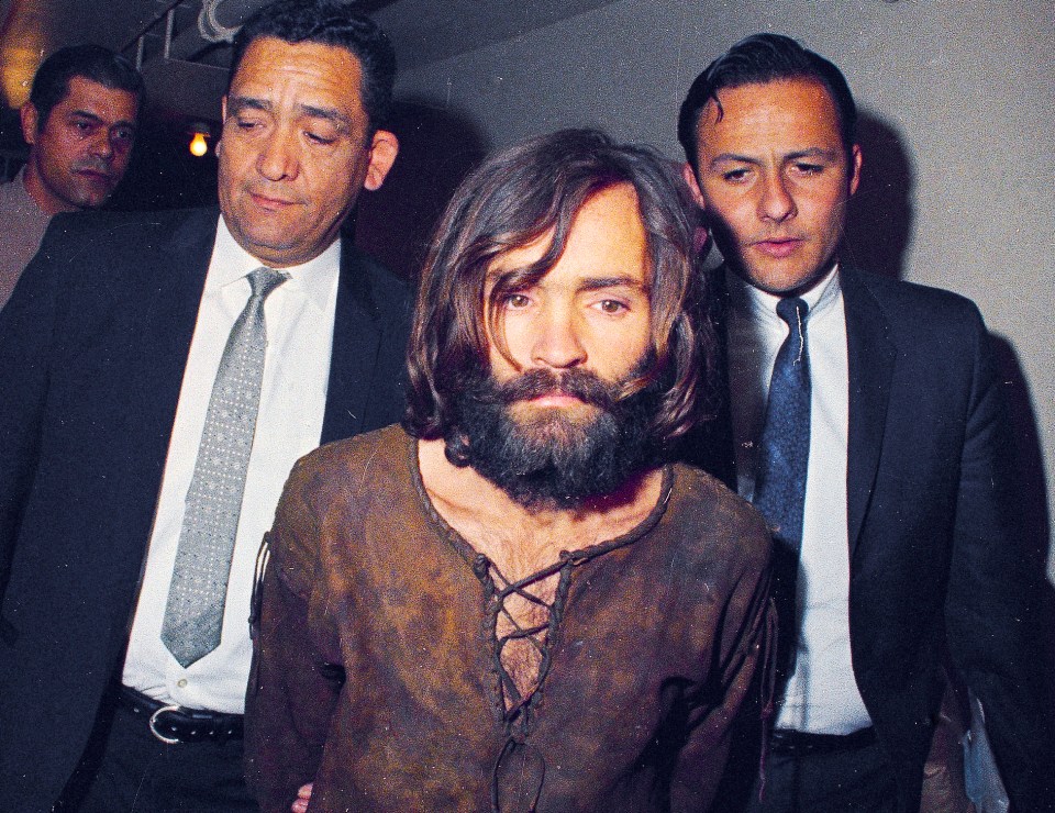 Charles Manson escorted by guards.