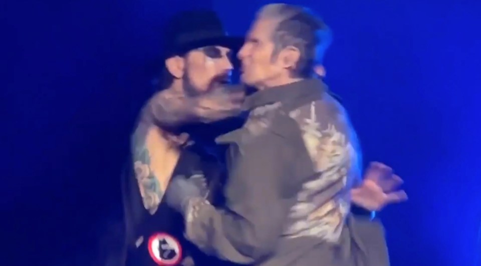 two men are hugging each other on a stage .