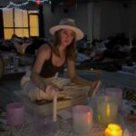 Woman in hat playing sound bowls.