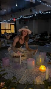 Woman in hat playing sound bowls.