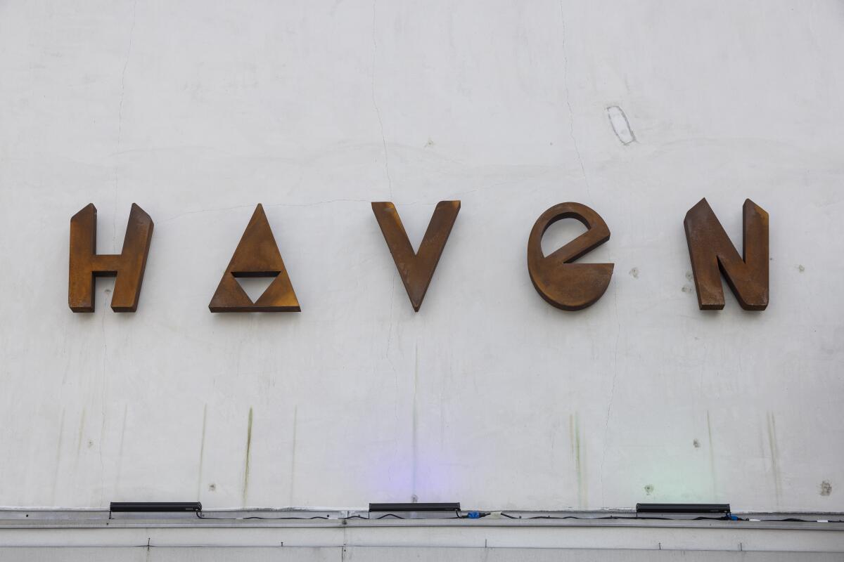 Angular letters spell "Haven" on a white building wall.