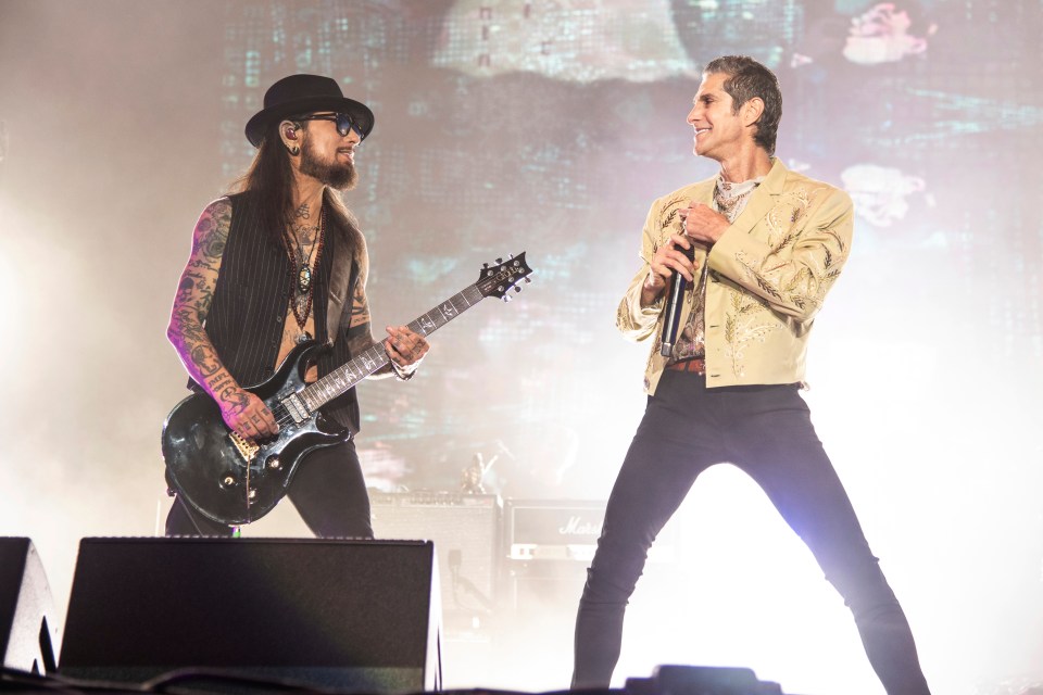 a man playing a guitar and another man singing on stage