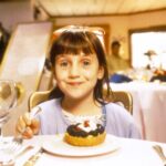 Mara Wilson as Matilda eating dessert in a restaurant.