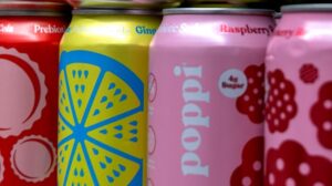 Cans of Poppi soda are displayed inside of a store