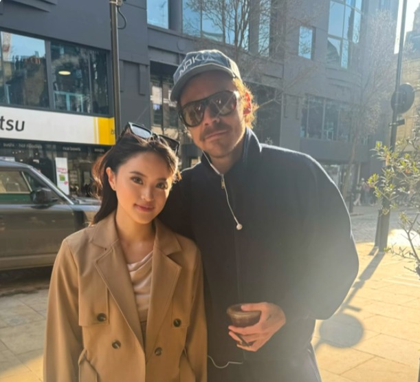 Harry Styles and a woman posing for a photo while getting coffee in Soho.