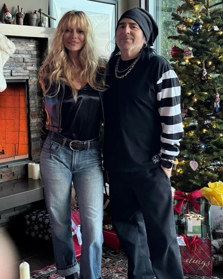 Couple posing by a Christmas tree.