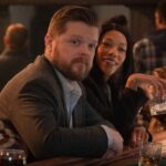 In a still from Daredevil: Born Again, Foggy Nelson (played by Elden Henson) leans against a bar and looks toward the camera.