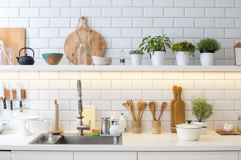 closeup of a kitchen with white subway tile backsplash and open shelving