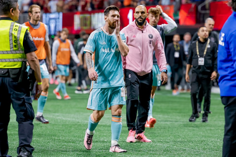 Lionel Messi leaving the soccer field, looking upset.